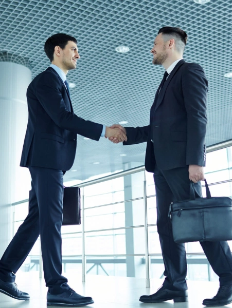 Top Business Collaboration Services Company in Mumbai A pair of professional men shaking hands in an office setting indicates that the joint venture.